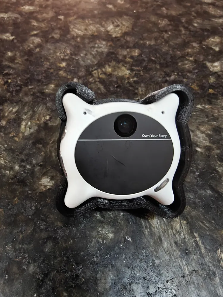 Looki L1 camera sitting in its printed black ABS cradle