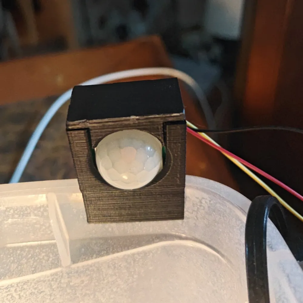 Printed case holding an HC-SR501 motion sensor, front view